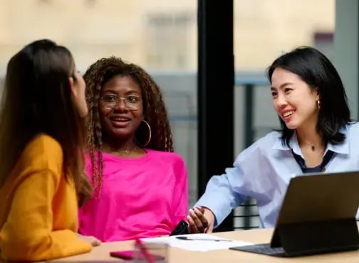 3 femmes discutant autour dun bureau